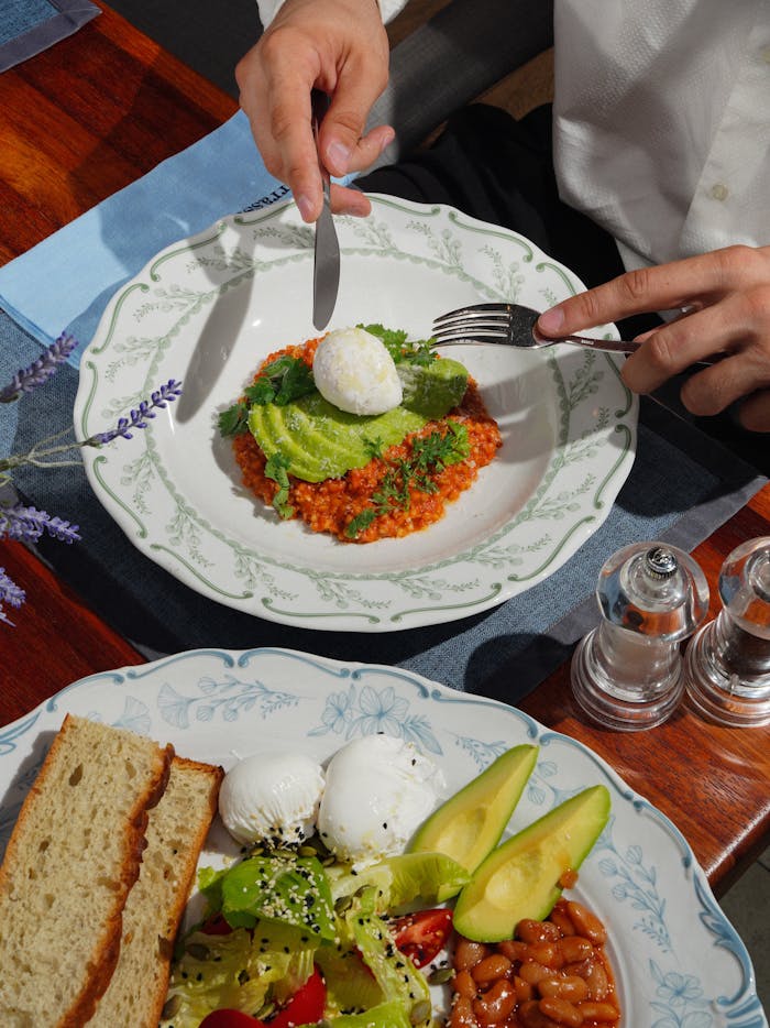 Top-down view of a stylish breakfast with avocado salad and poached egg.